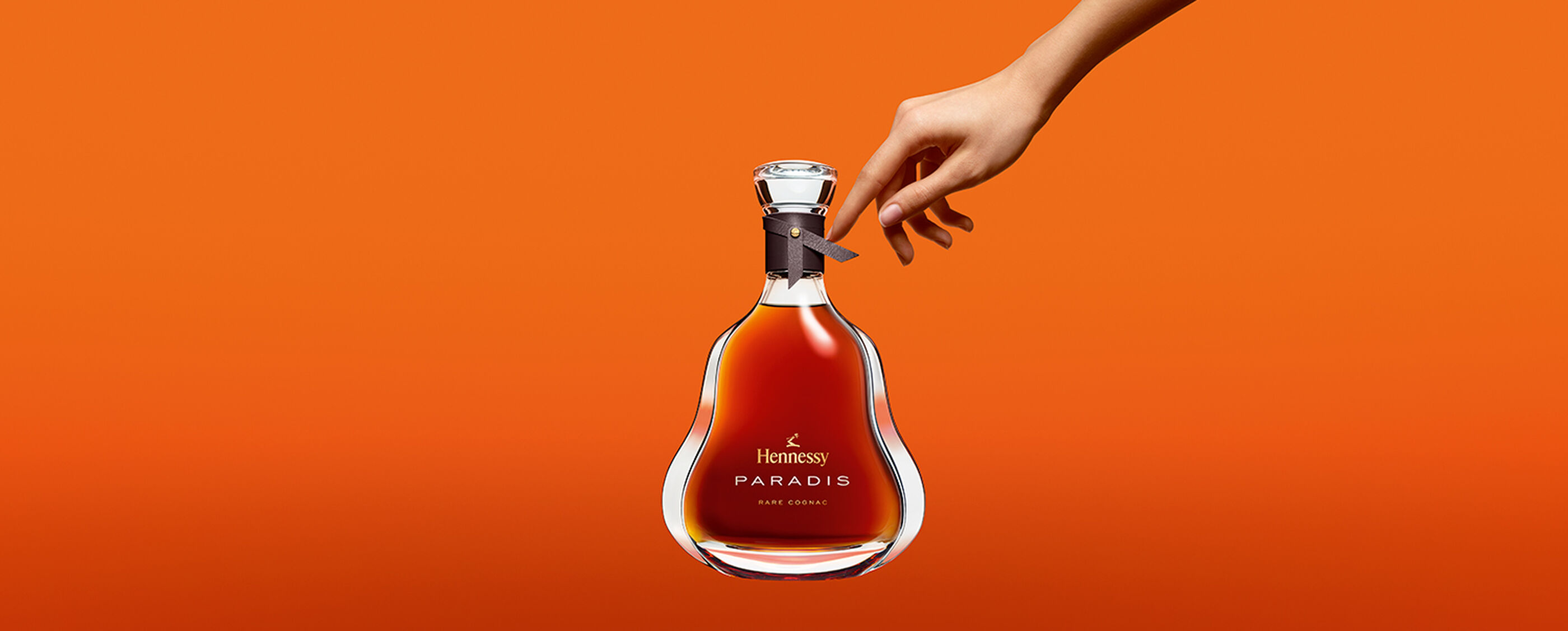A hand touches a Hennessy Hands bottle.